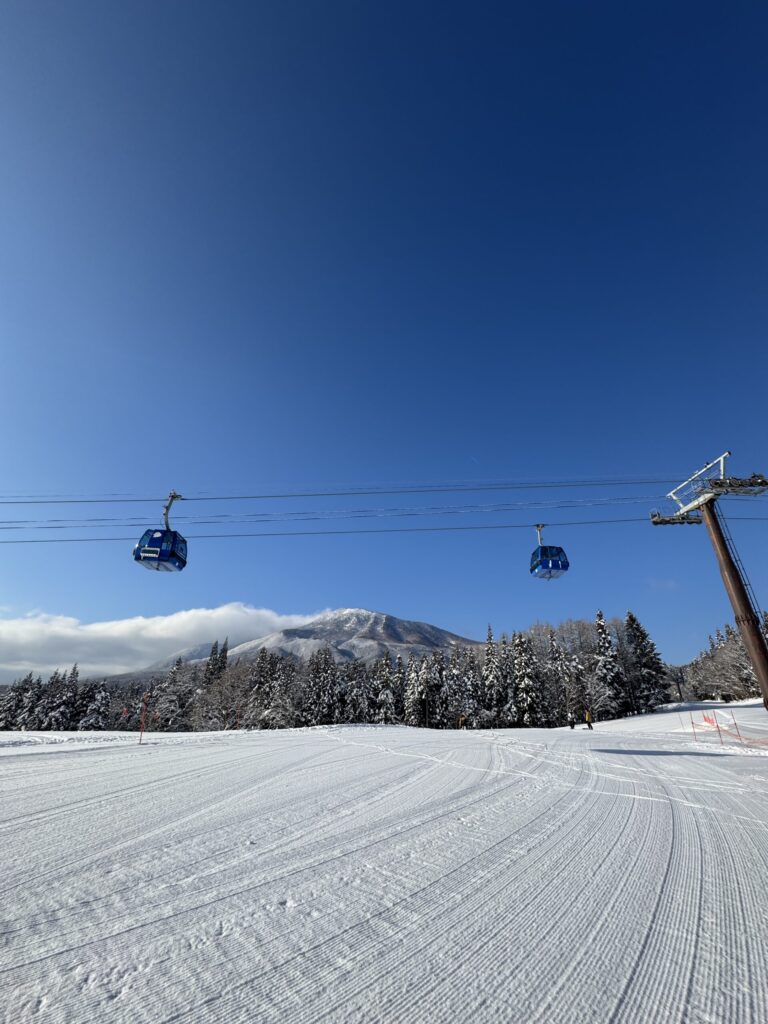 Freshly groomed slope and gondola on a bluebird day / 青空の下のゲレンデとゴンドラ